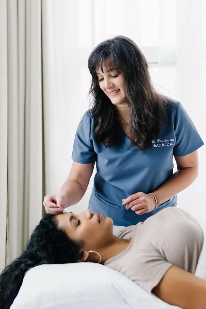 A healthcare professional in scrubs and a reclining female patient in Portland, Oregon.