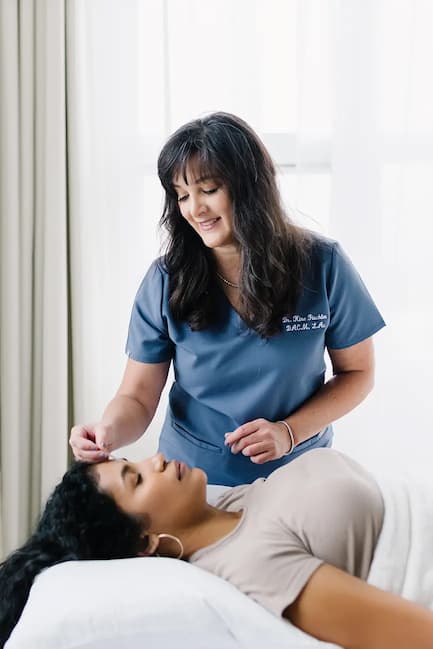Dr. Kiné Fischler performing acupuncture treatment on a relaxed patient at Willow Tree Acupuncture clinic in Portland Oregon